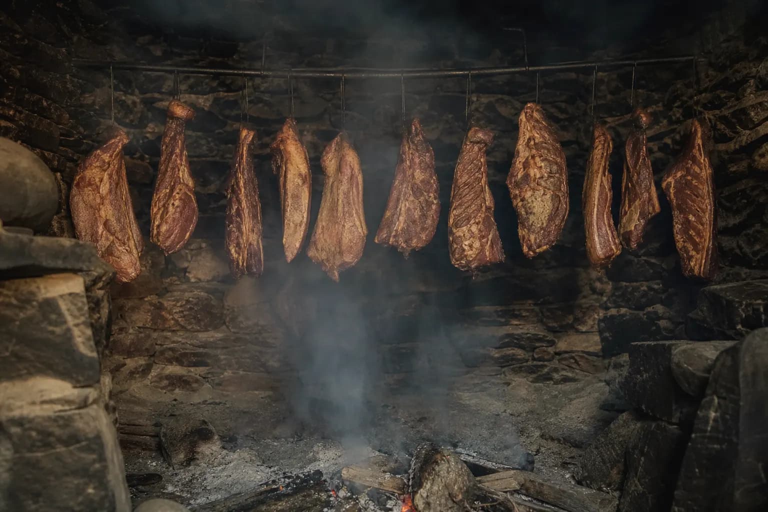 Beef pieces being smoked over oak and holm oak wood