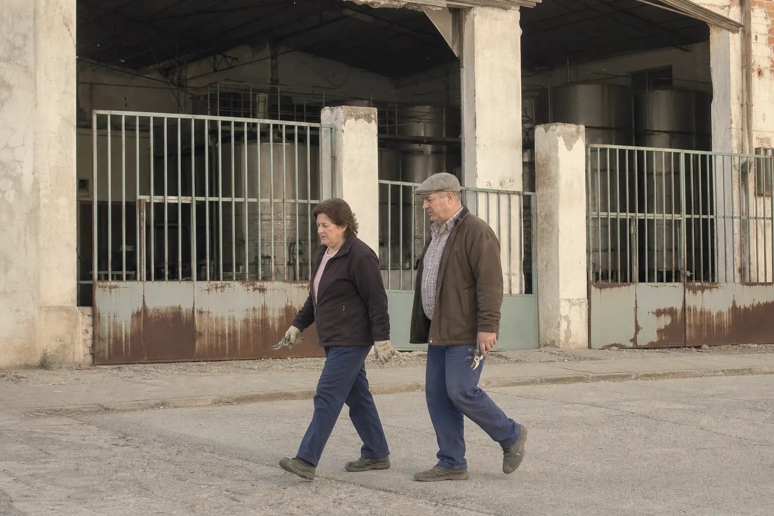 Rebeca and Ángel Moya walk past the closed wine cooperative