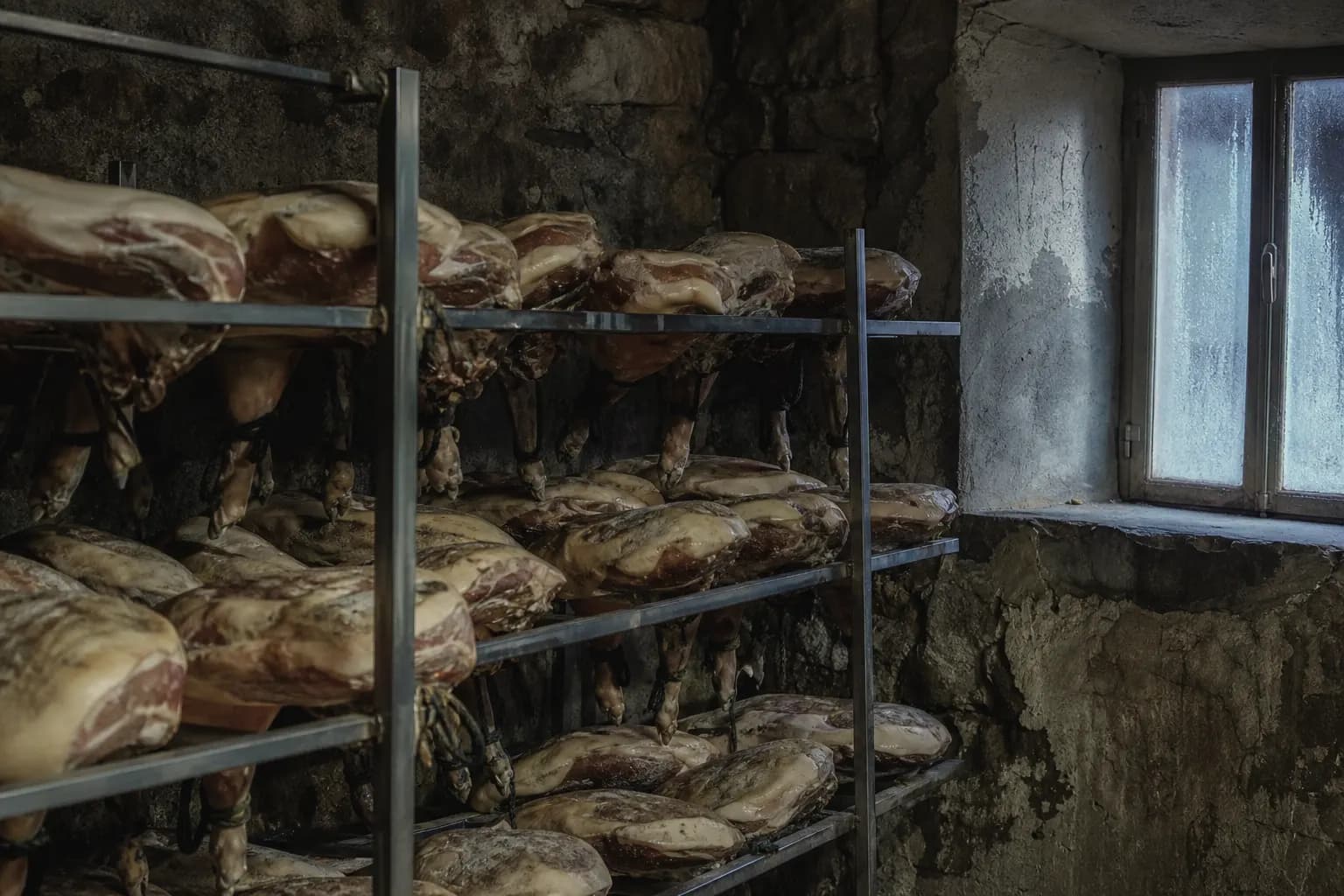 Washed hams resting in the cold on racks in the drying house