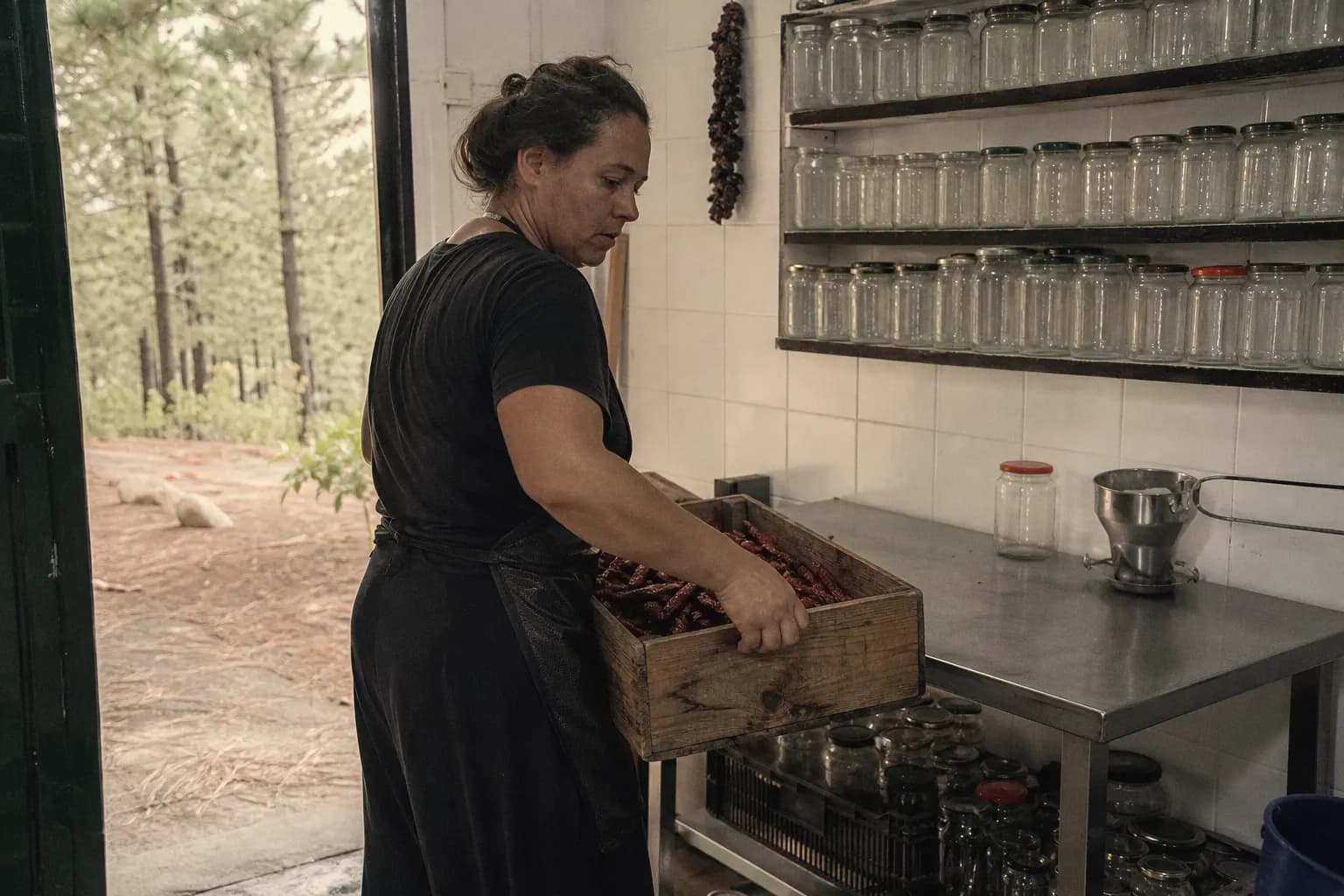Yurena Pérez carries crates of dried peppers into her small workroom in Puntagorda
