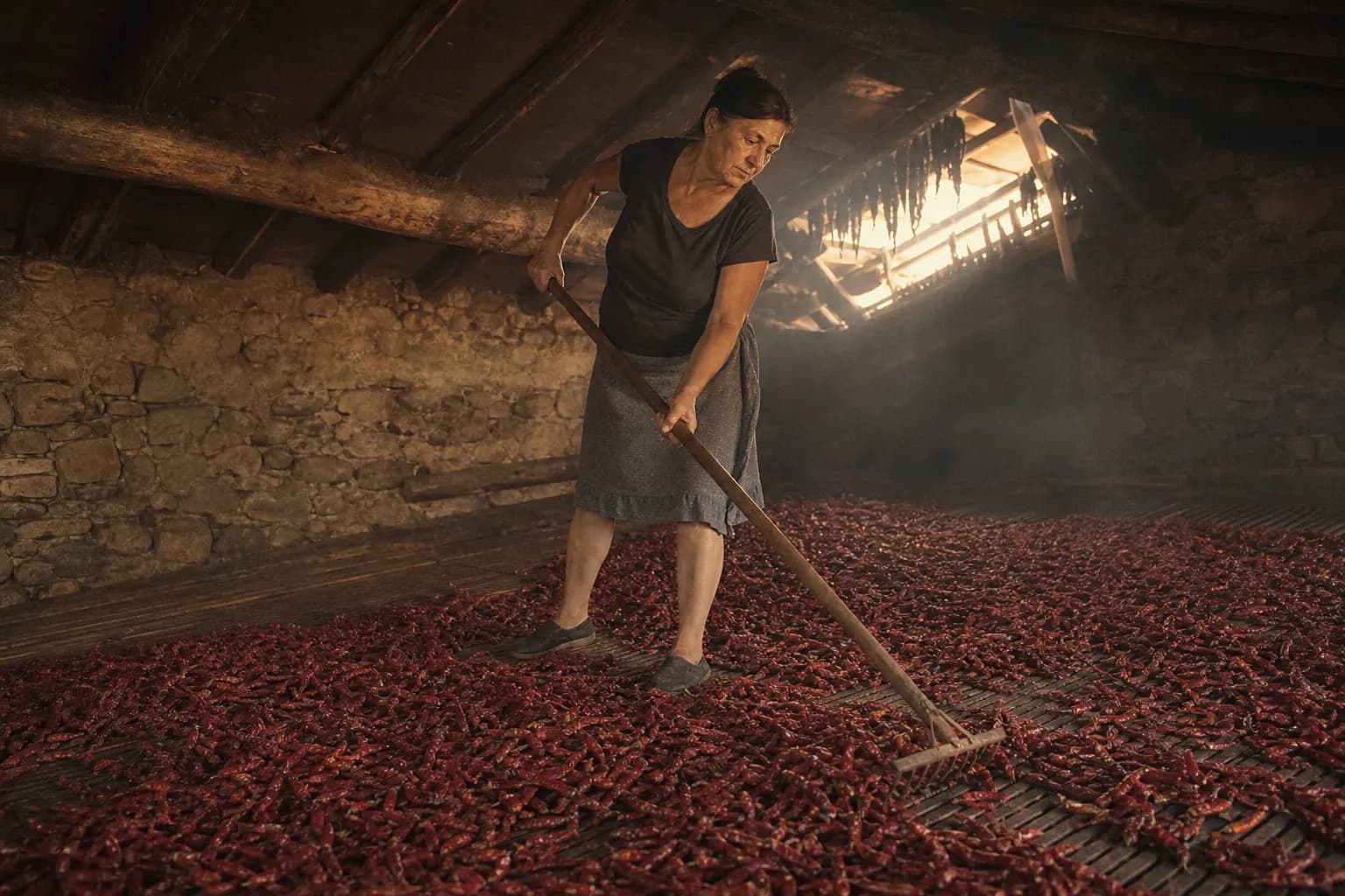 Marisa Tovar spreads the peppers over the slatted wooden floor
