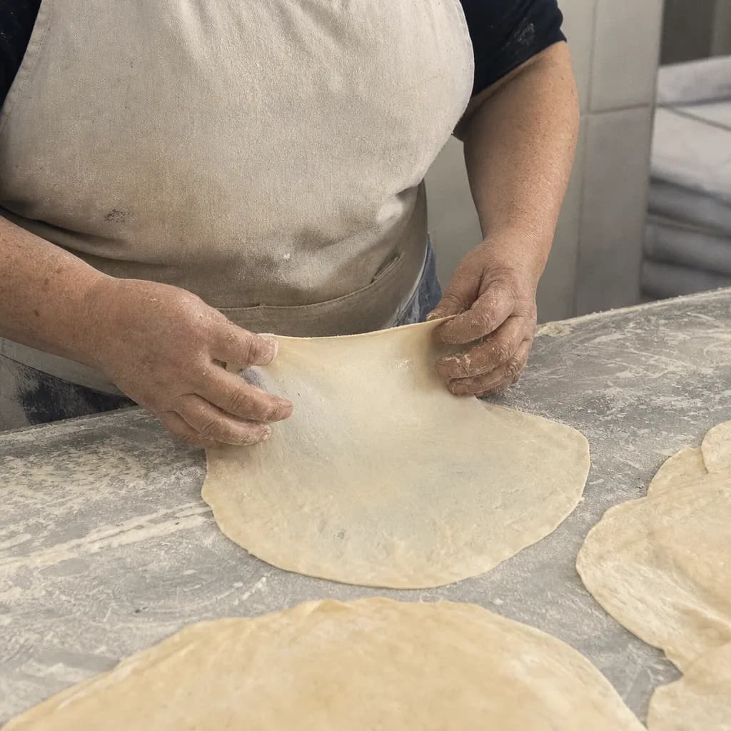Inma Rivas's hands stretch a torta until it is very thin