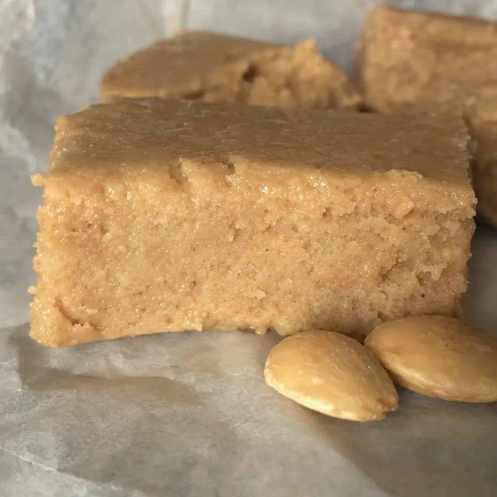 Piece of soft oily Jijona turrón beside marcona almonds