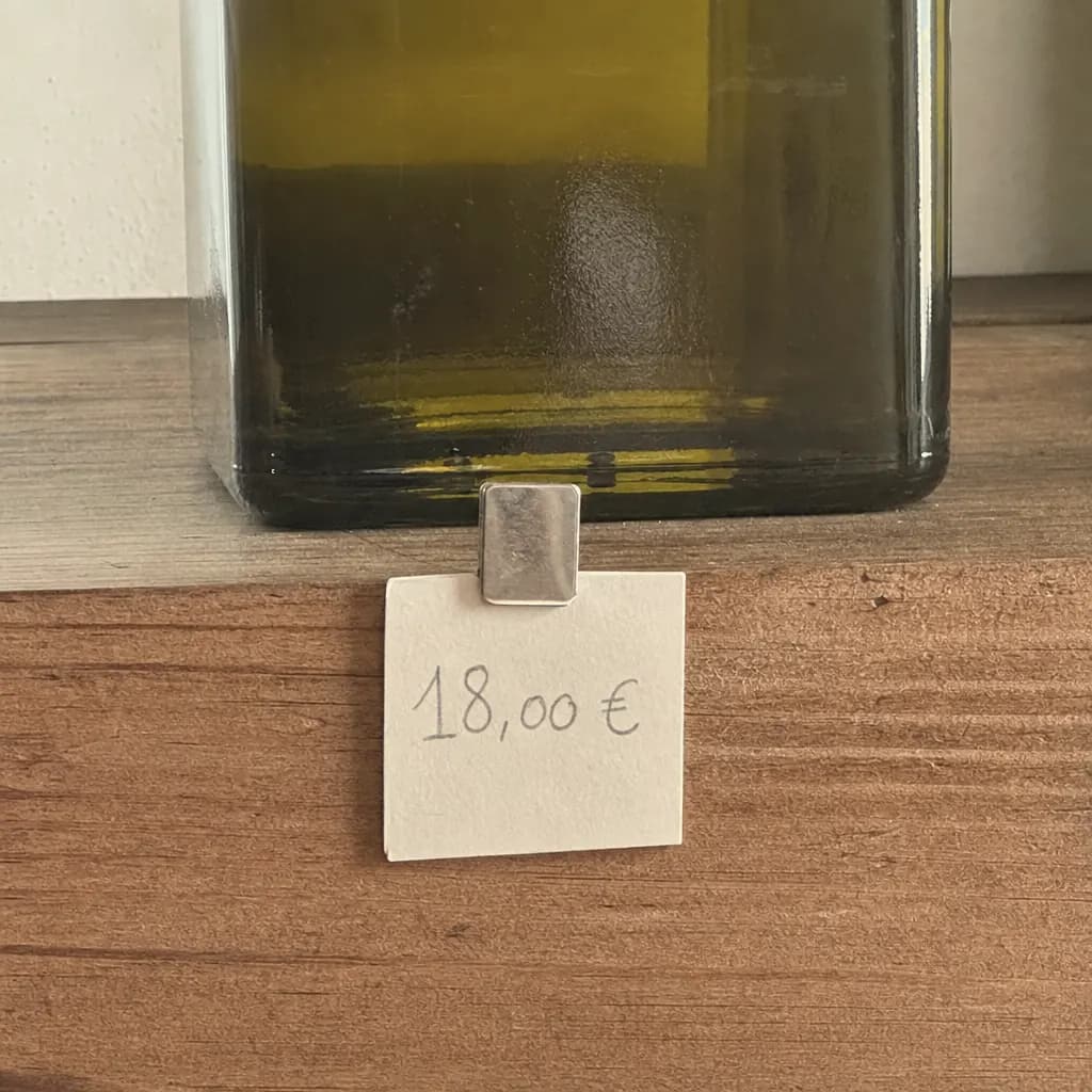 Handwritten price label on the edge of a shelf