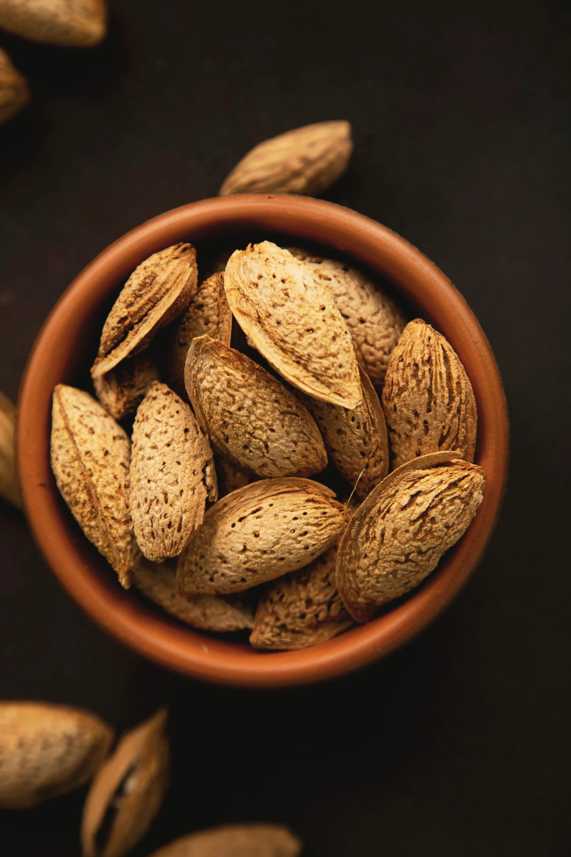 Almonds in their shell in a clay bowl