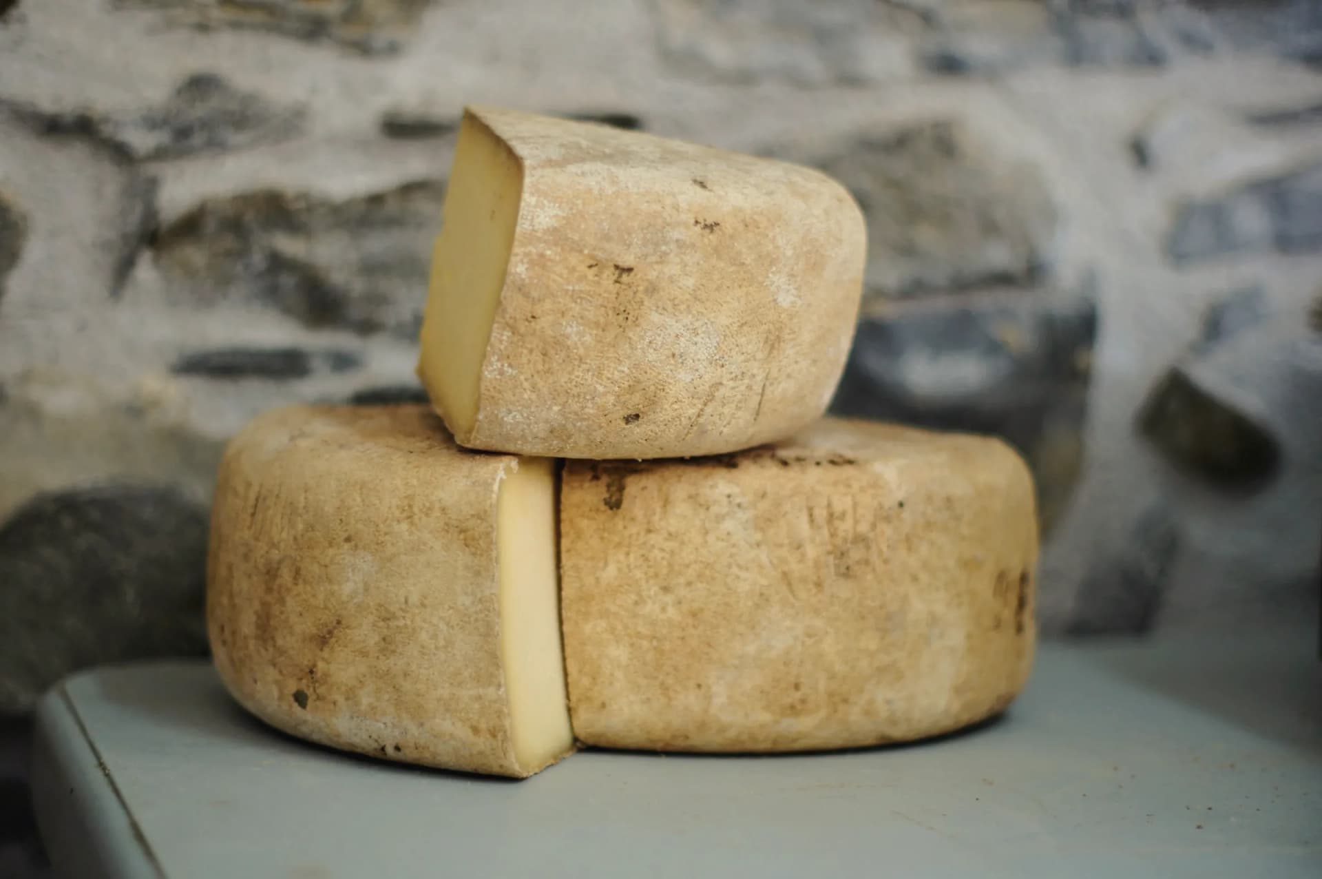 Two natural-rind cheeses, one of them cut open