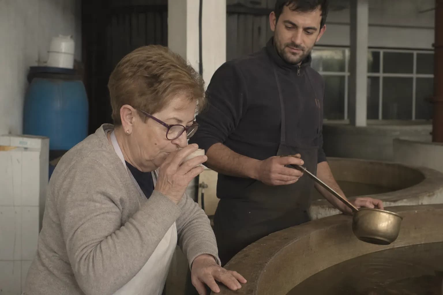 Pili tastes the brine from a vat while her son Iván Garcés waits