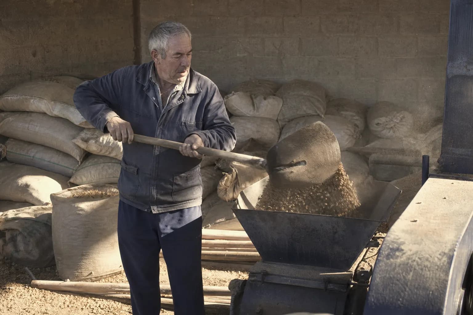 Ángel Moya shovels pistachio shells into the dryer as fuel