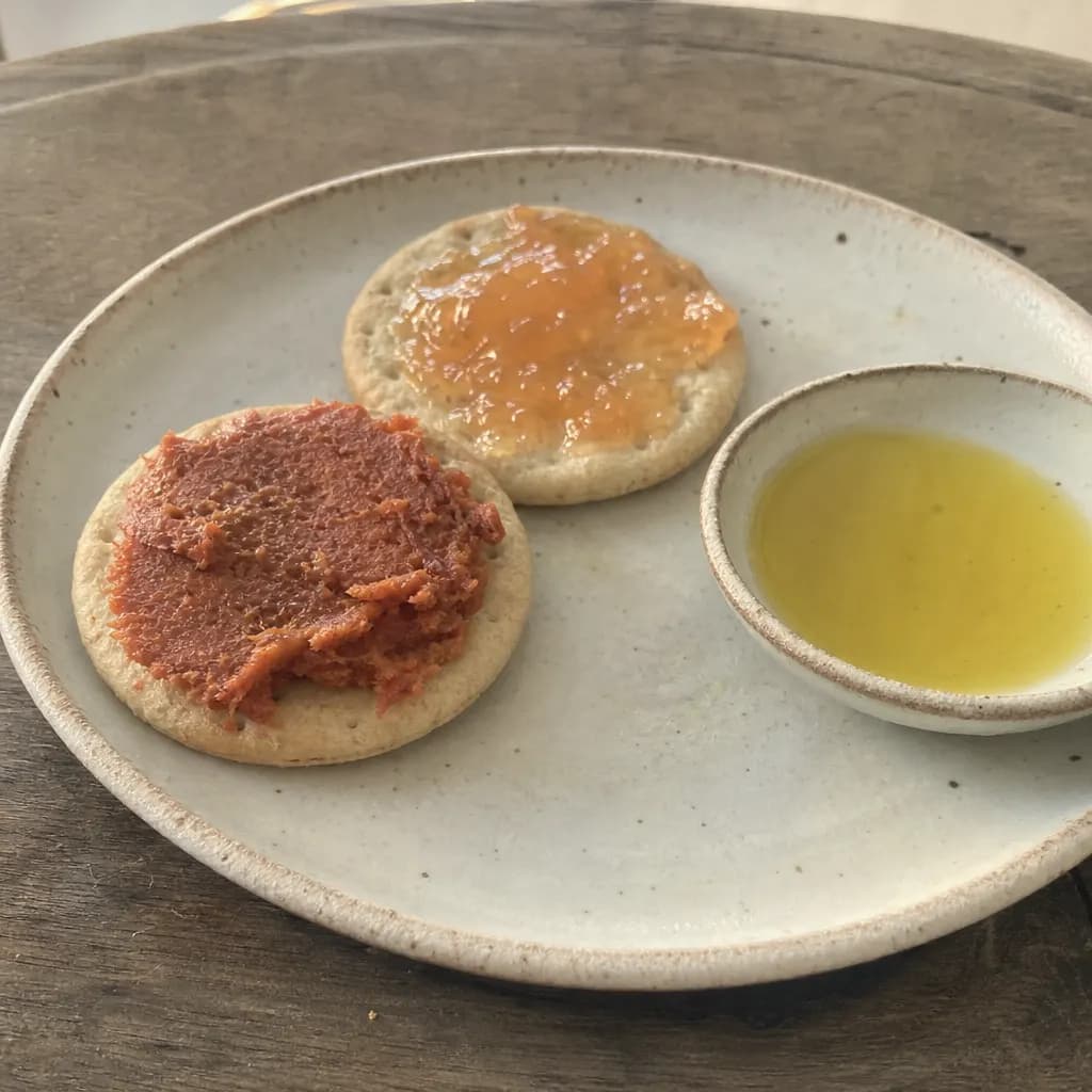 Olive oil crackers topped with sobrasada and with jam on a plate