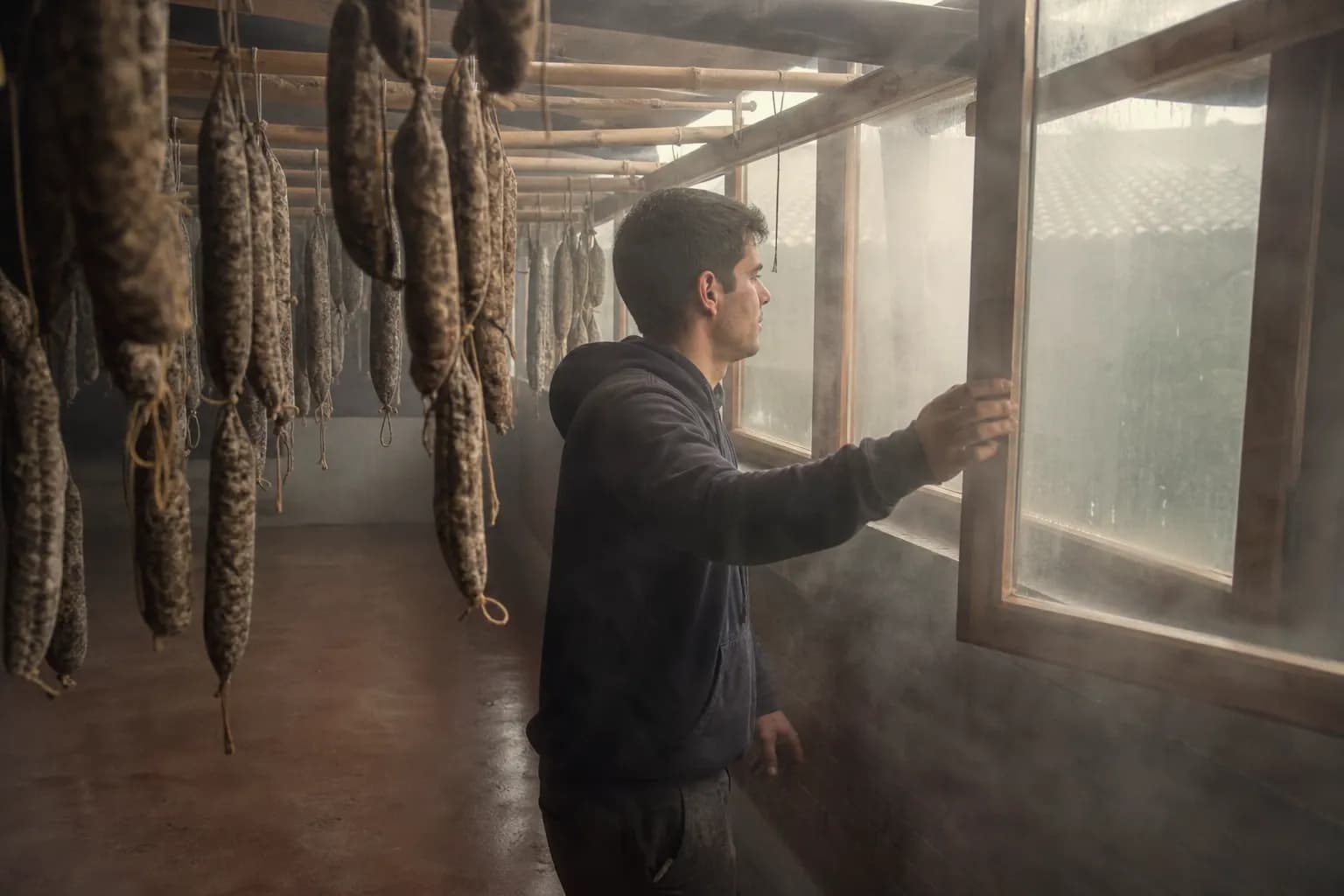 Pol Comas opens a drying house window and the fog drifts in