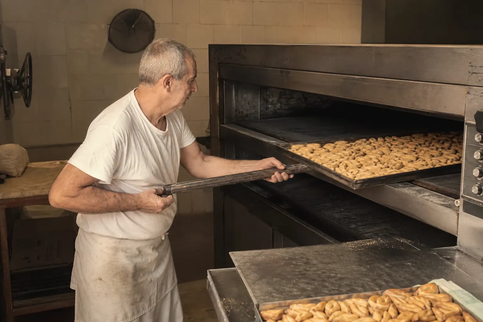 Curro Montero slides trays of picos into the oven for a long slow bake