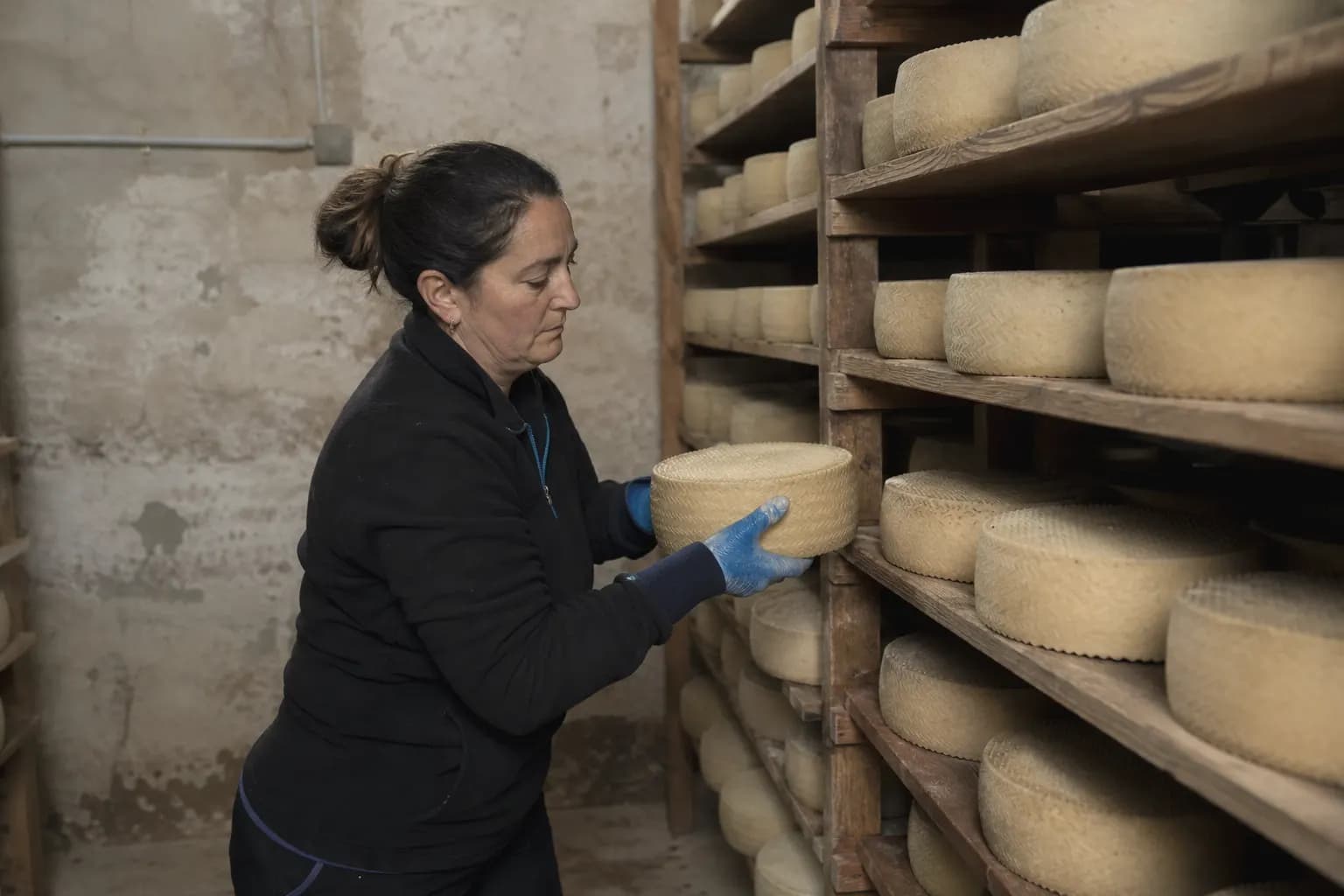 Gema Carrasco turns the cheeses in the cellar